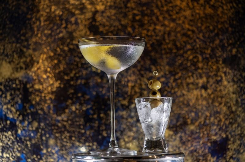 Martini with lemon peel and a side of olives on a silver tray served at The Capital Hotel, Apartments and Townhouse