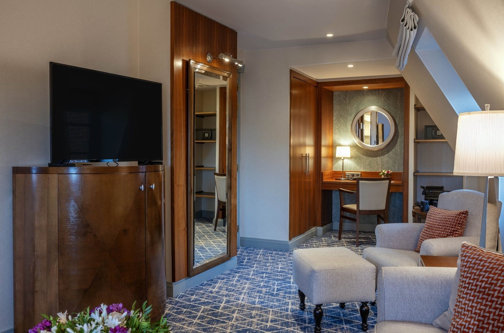 Junior Suite TV lounge area featuring a sofa near the working desk at Warwick Grand Place Brussels