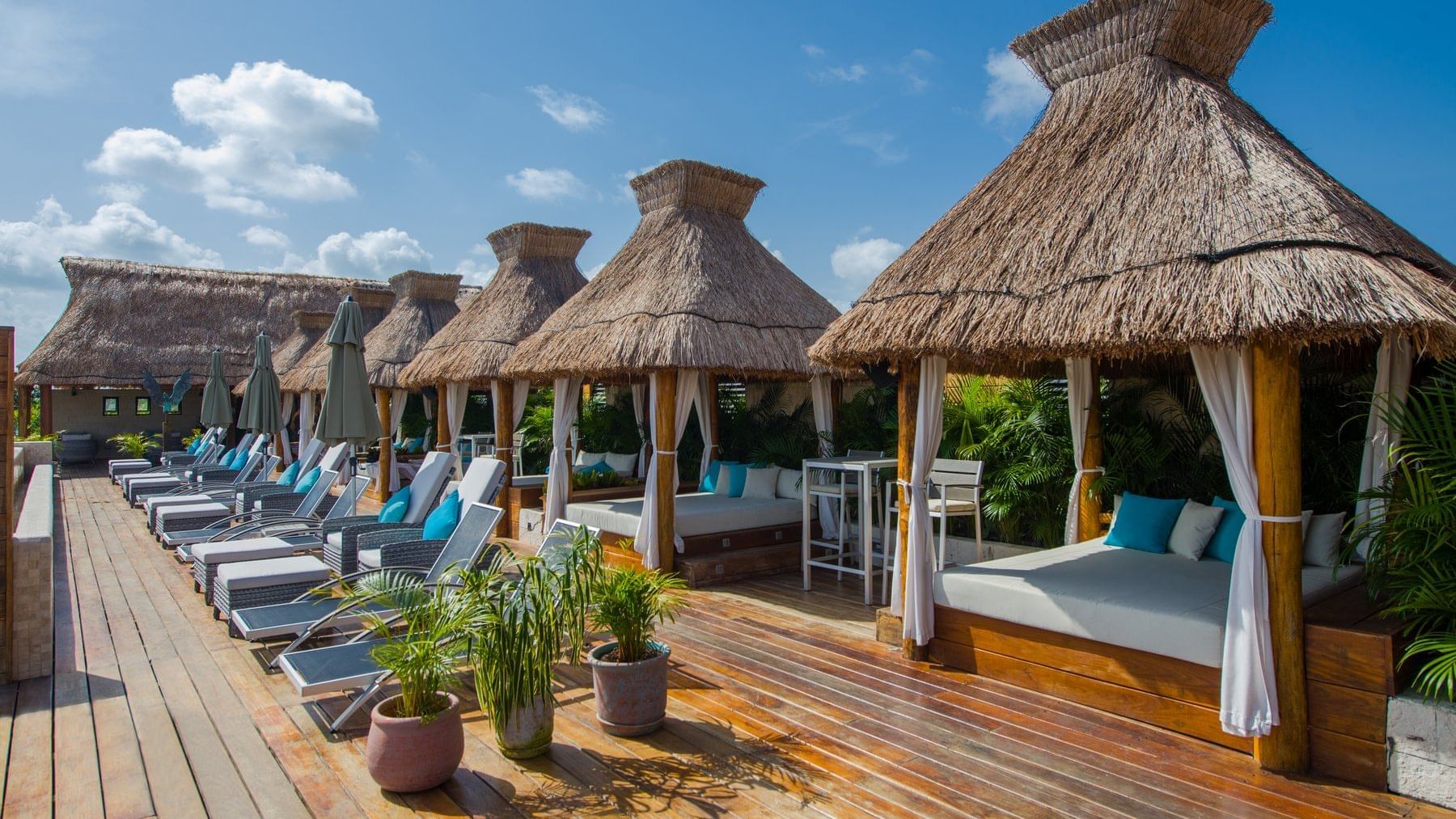 Luxury lounge cabanas by the pool at Naay Tulum Curamoria