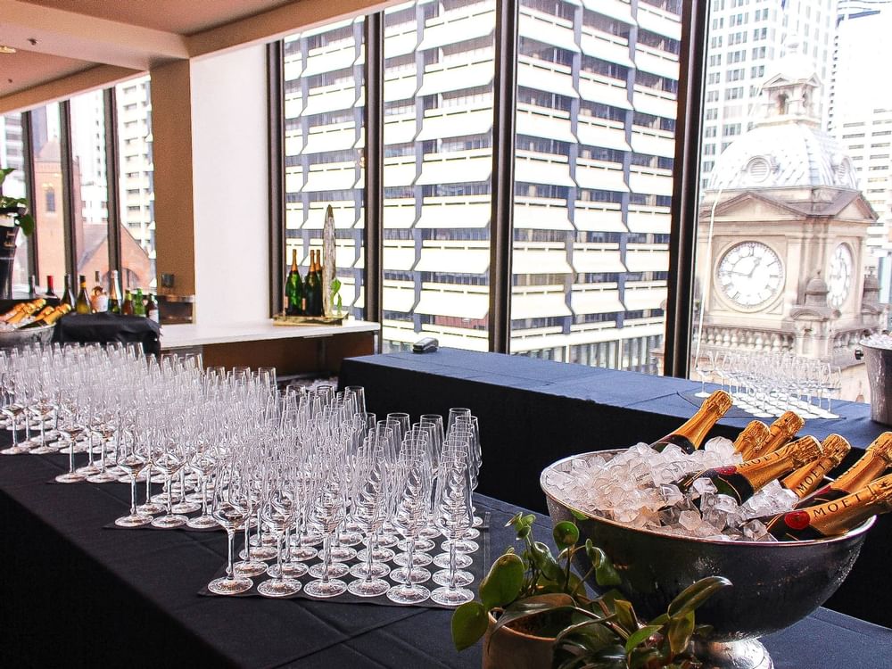 An elegant table featuring multiple glasses of champagne with champagne bottles at Sofitel Brisbane Central