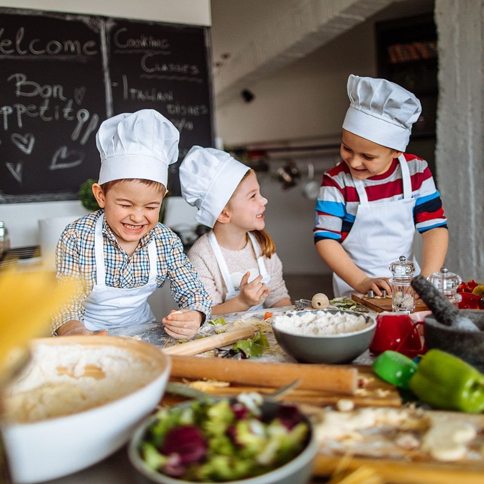Kids in chef hats baking at Falkensteiner Hotels