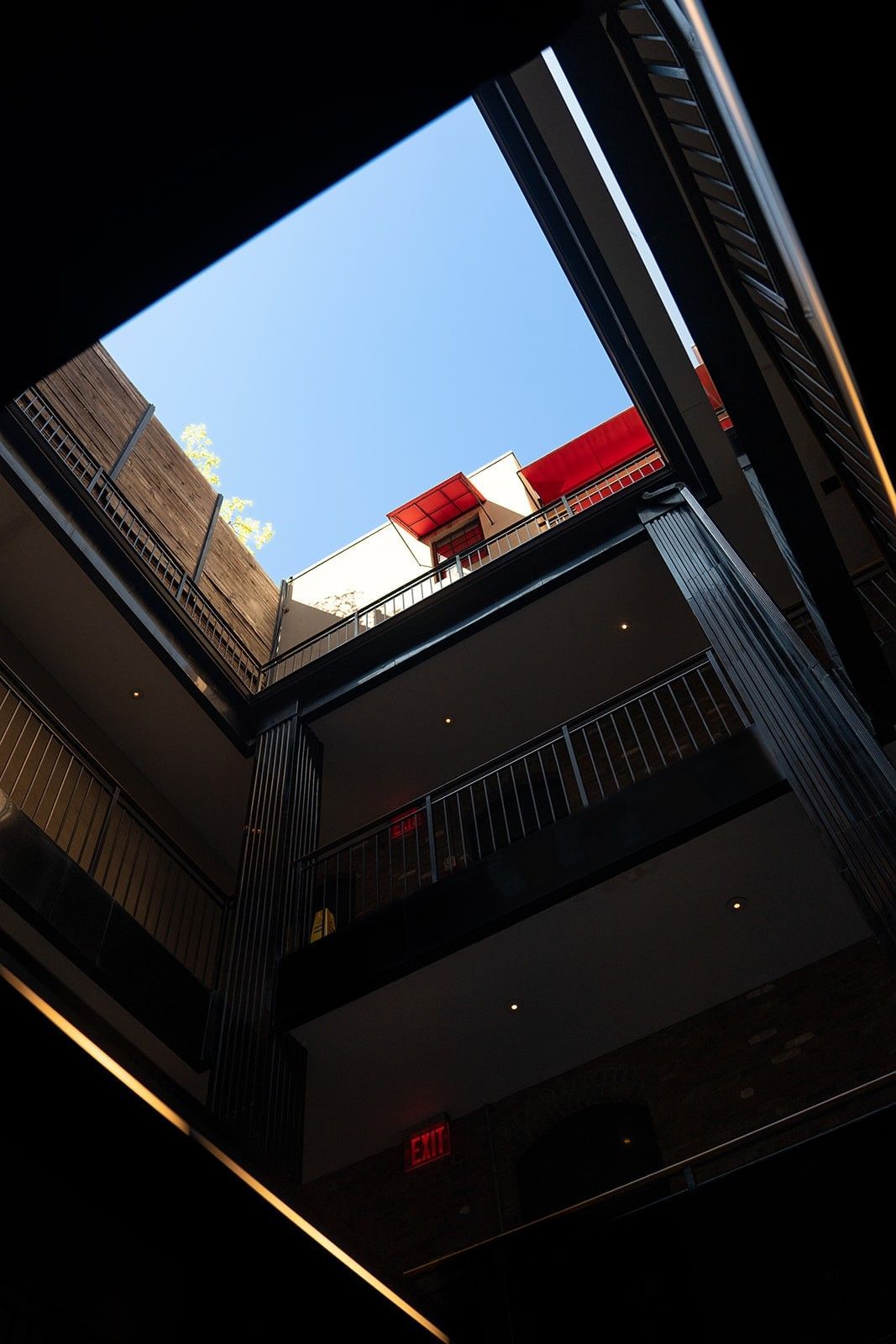 A courtyard with a skylight and a balcony with a red awning