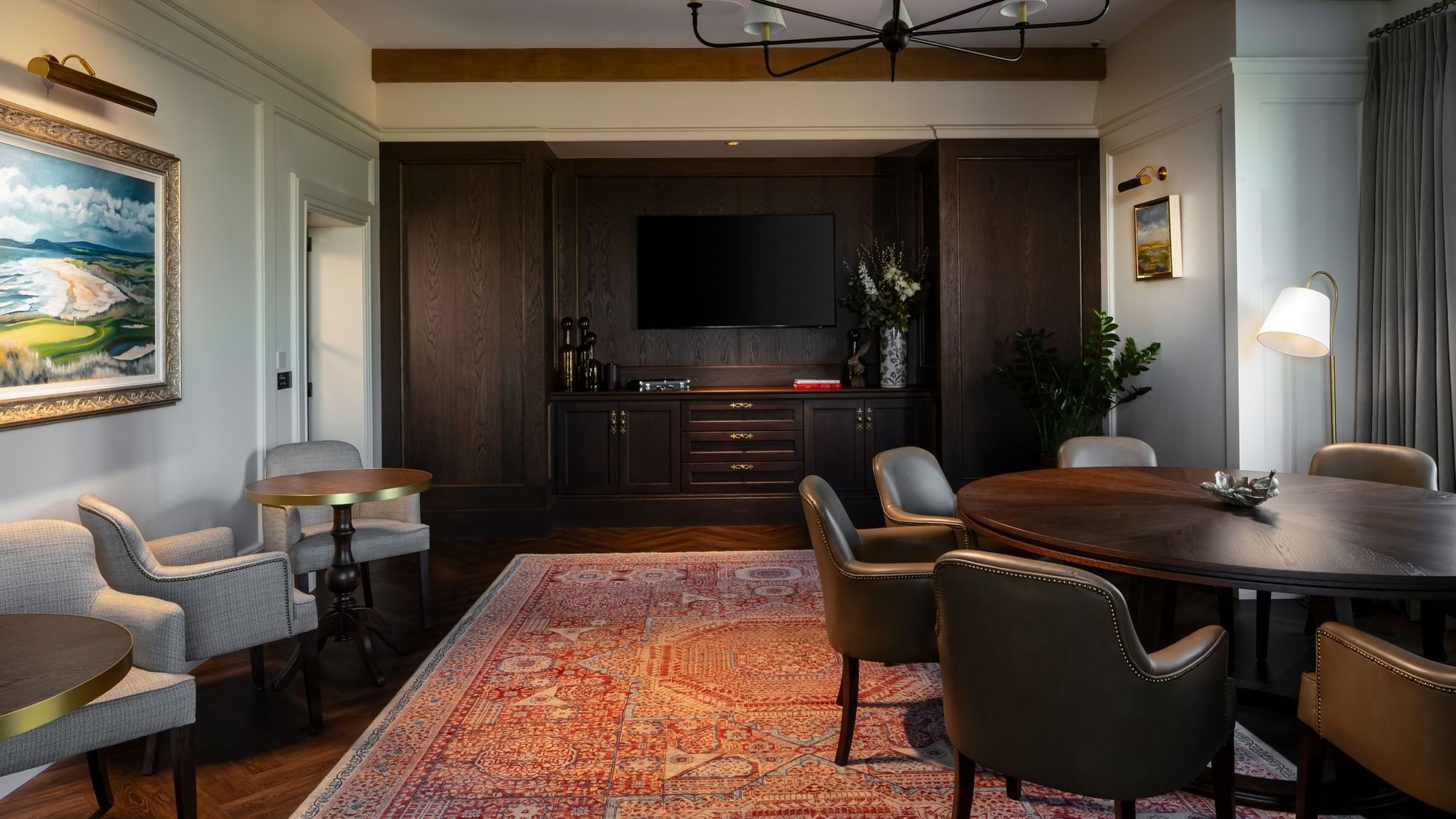 Luxurious lounge with a large rug, round tables, and a TV, at Dunluce Lodge, offering comfortable seating
