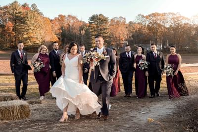 bride and groom walking with wedding party behind