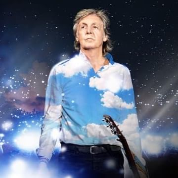 Paul McCartney holding a guitar with the image of the solar system behind him.