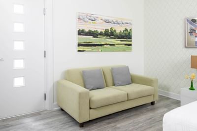 Comfy sofa & painting on the wall in Queen Premiere Spring Fling at Retro Suites Hotel