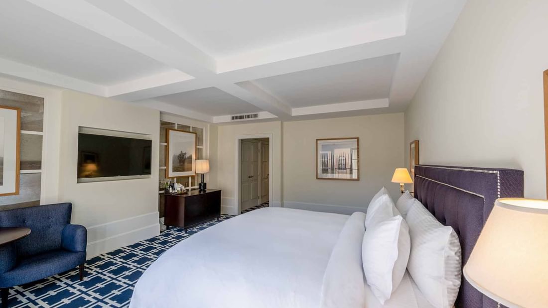 Deluxe Queen with a cozy bed, seating area, and elegant decorative touches at El Prado Hotel