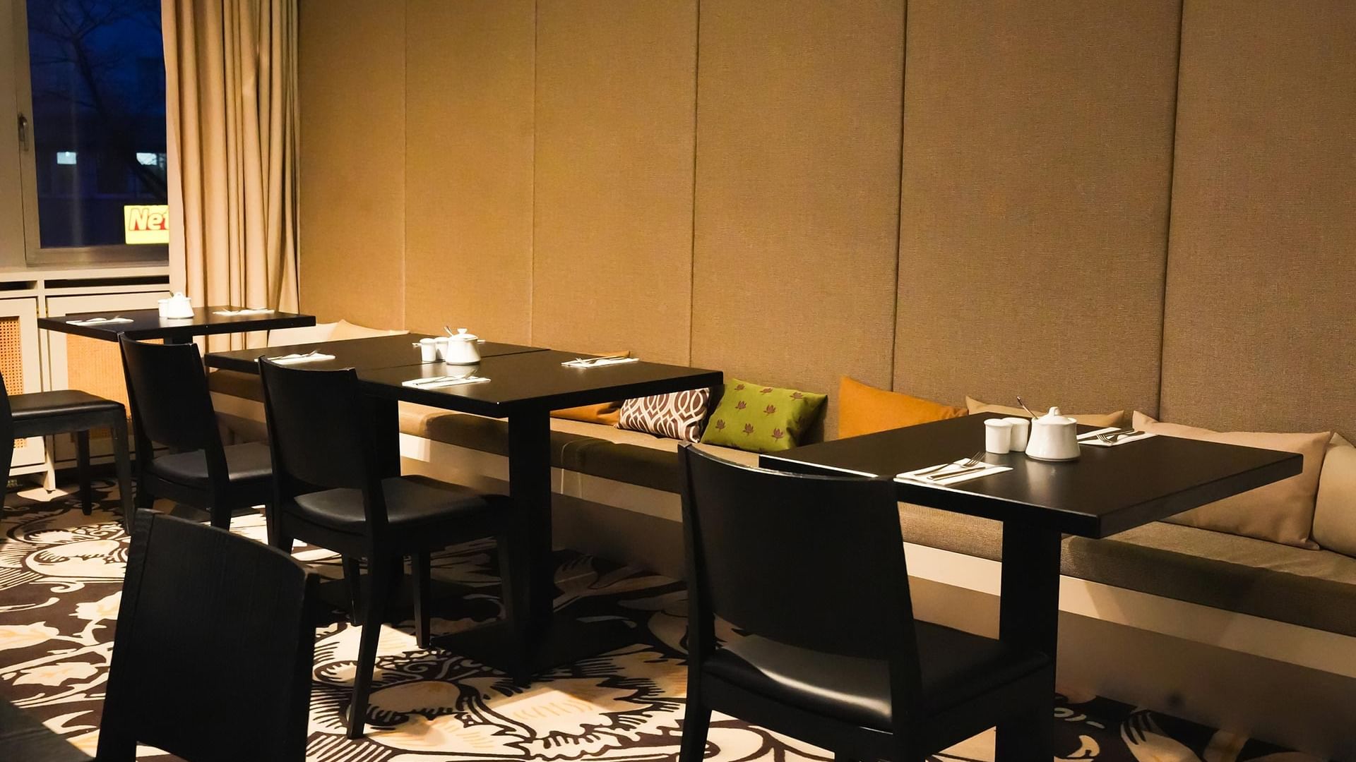 Elegantes Frühstücksrestaurant mit schwarzen Tischen und Stühlen am Sylter Hof Berlin.