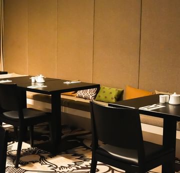 Elegantes Frühstücksrestaurant mit schwarzen Tischen und Stühlen am Sylter Hof Berlin.