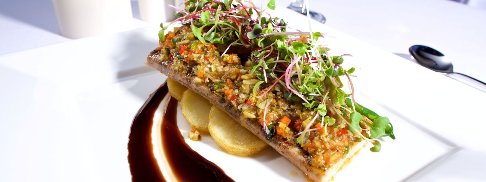 Seasoned fish fillet with roasted potatoes under fresh microgreens in Abbiocco at Warwick Paradise Island Bahamas