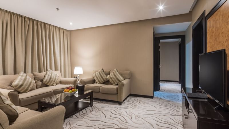 Family Suite living area with comfy sofas and carpeted floor at Warwick Al Khobar