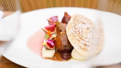 Plat de figue et de crème avec une fine crêpe sur une assiette blanche.
