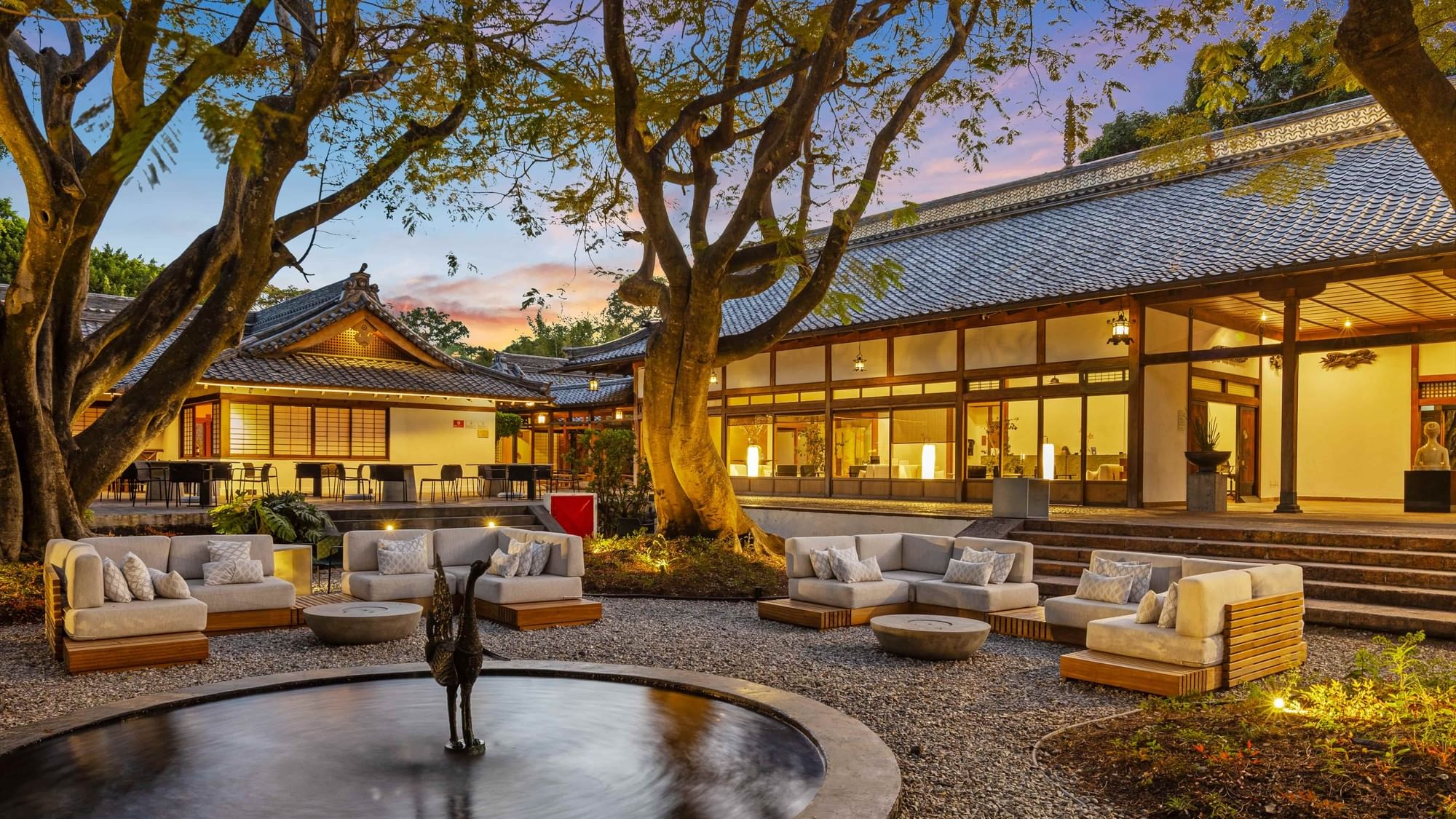 Cozy outdoor seating area with couches and a fountain in front of the Grand Fiesta Americana Sumiya Cuernavaca.