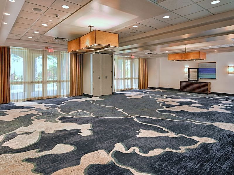 Palominito meeting room with intricate carpet design, warm lighting, and large windows at El Conquistador Resort