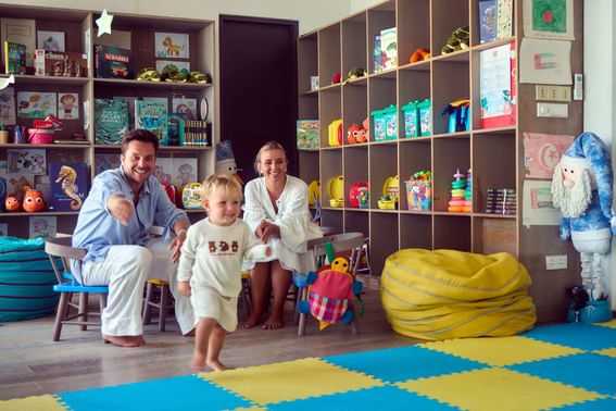 Child playing in a playroom with toys on shelves and floor mats at Grand Park Kodhipparu, Maldives