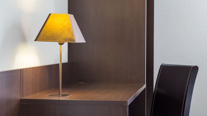 A lamp on the working desk in a room at Hotel Acadine