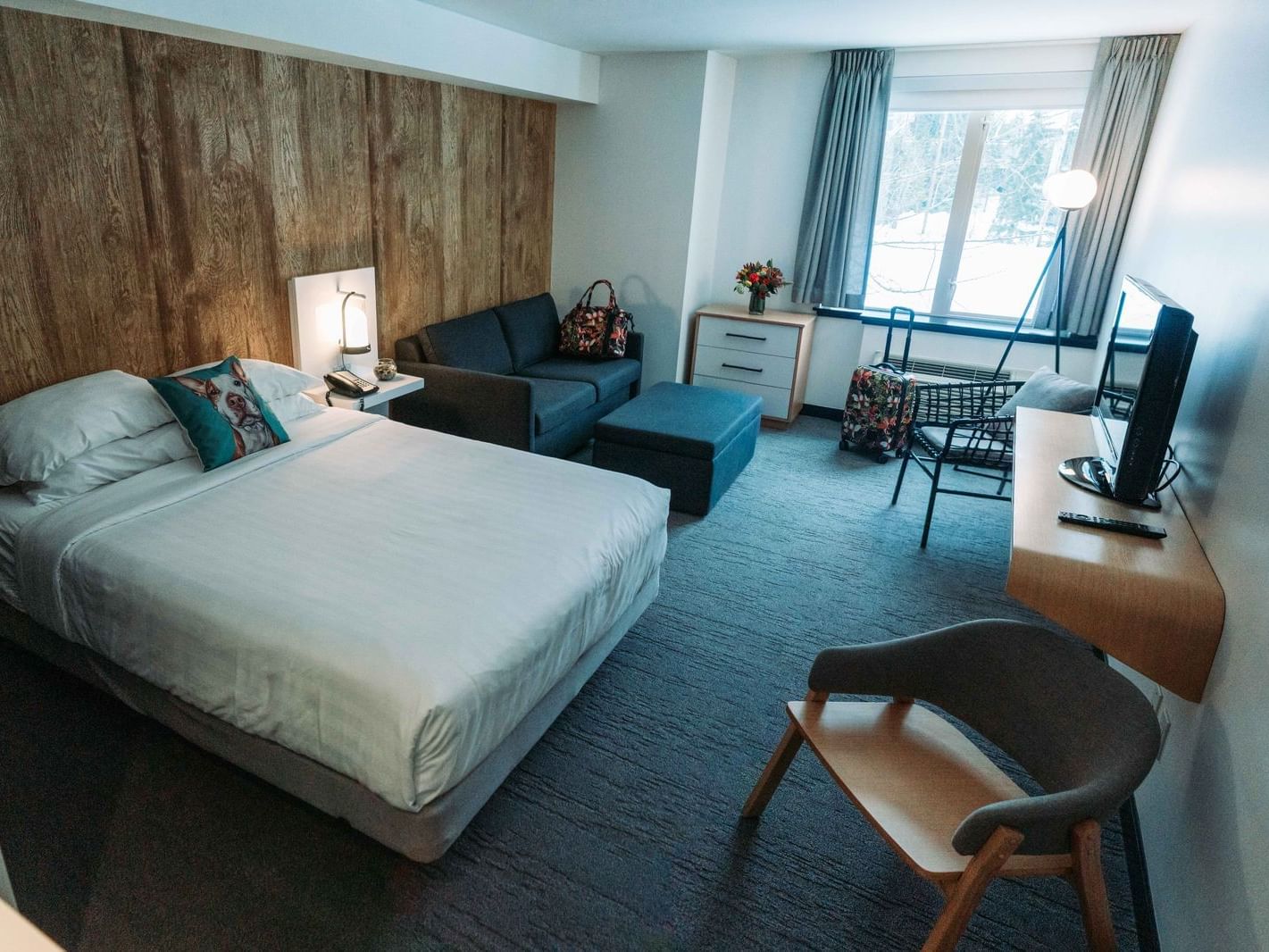 Bed and couch in hotel room with window