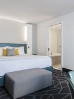 Bed with ottoman near doorway to bathroom in Penthouse Crescent at Warwick Le Crystal Montreal