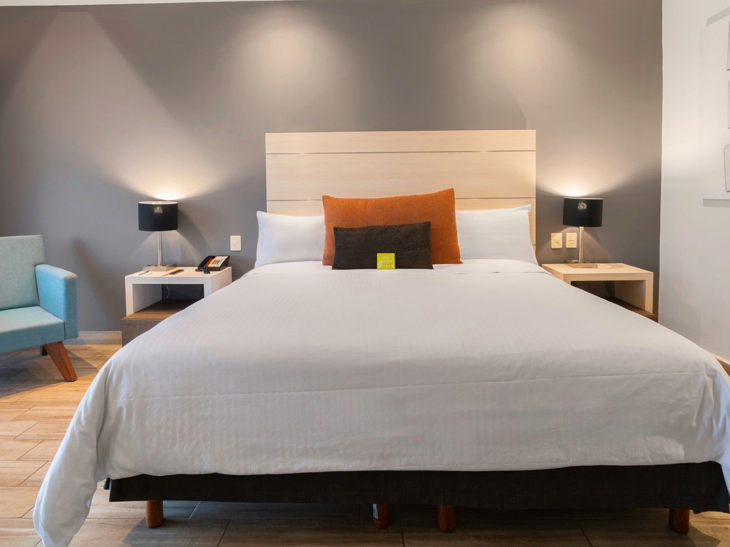 Habitación De Lujo King con cama grande, silla y decoración moderna en Real Inn Perinorte Tlalnepantla.