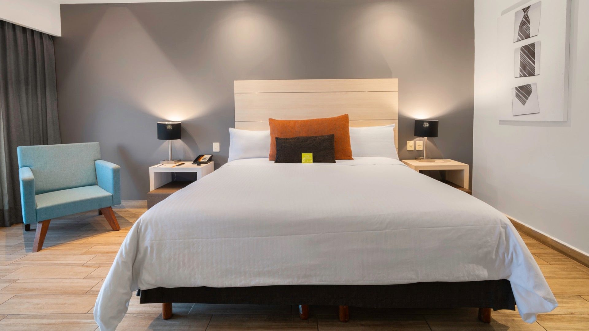 Habitación De Lujo King con cama grande, silla y decoración moderna en Real Inn Perinorte Tlalnepantla.