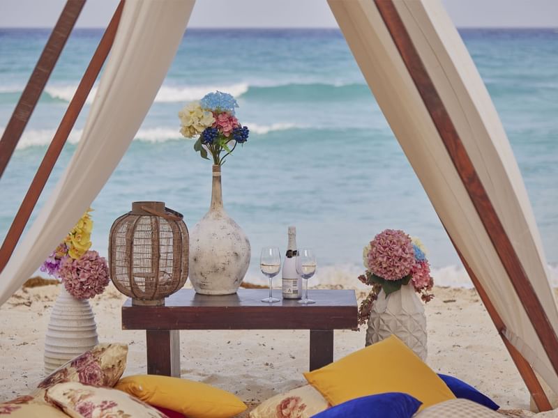 Cabaña de playa con bebidas y flores en FA Hotels & Resorts
