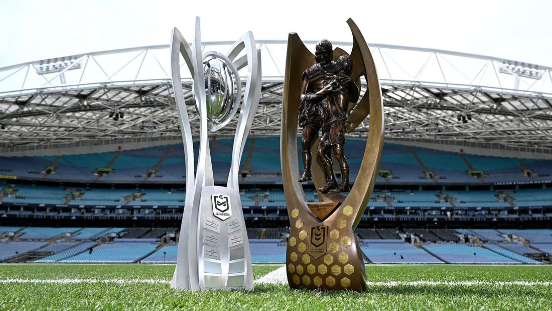 NRL and NRLW Grand Final 2026 trophies on the field in front of an empty stadium.