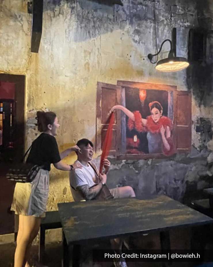 Couple posing by a wall art in Kwai Chai Hong Street, a famous local attraction near Imperial Lexis Kuala Lumpur