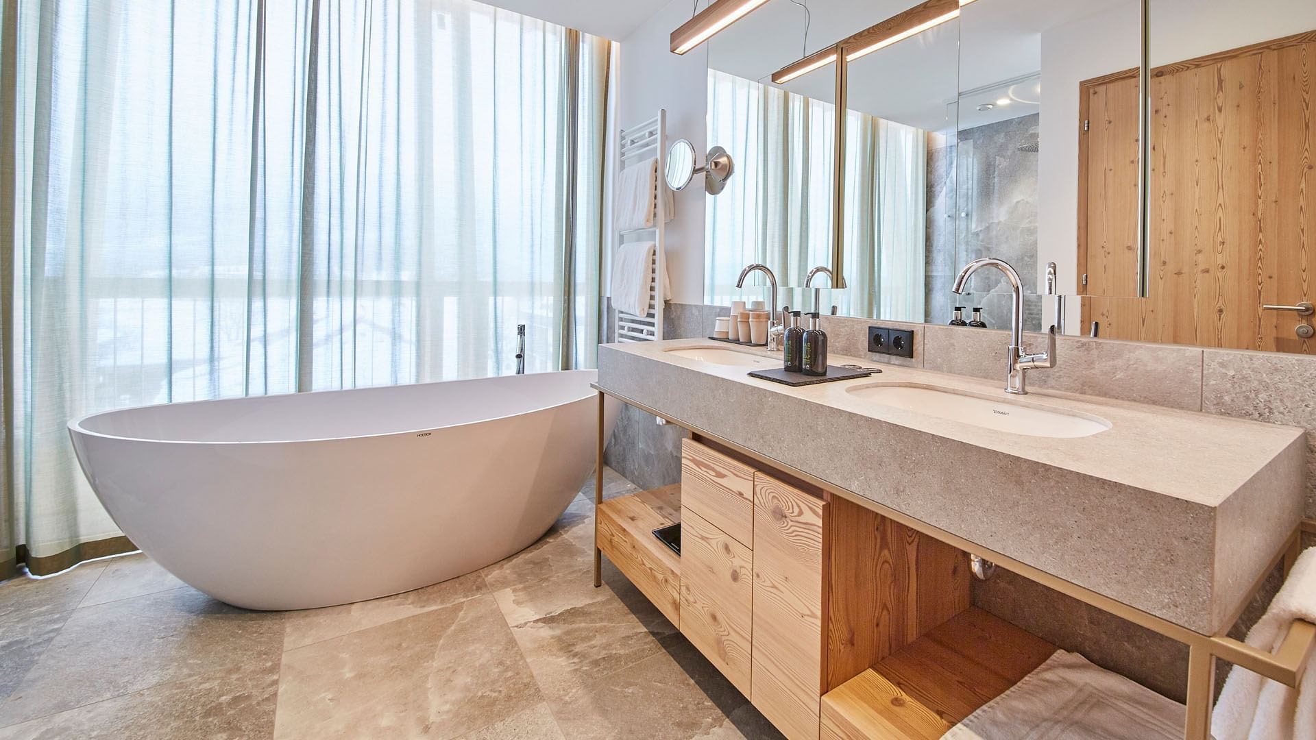 Bathroom vanity & tub in Summit Suite at Falkensteiner Hotels