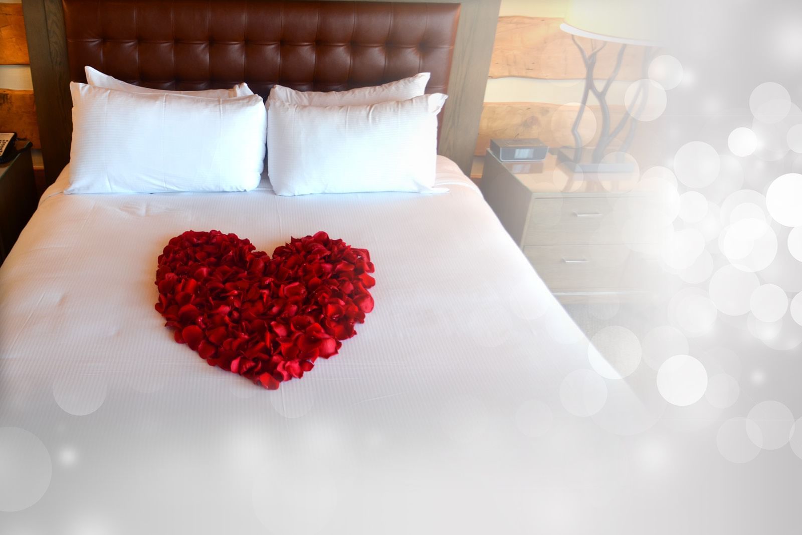A queen size bed with a heart made of roses on it