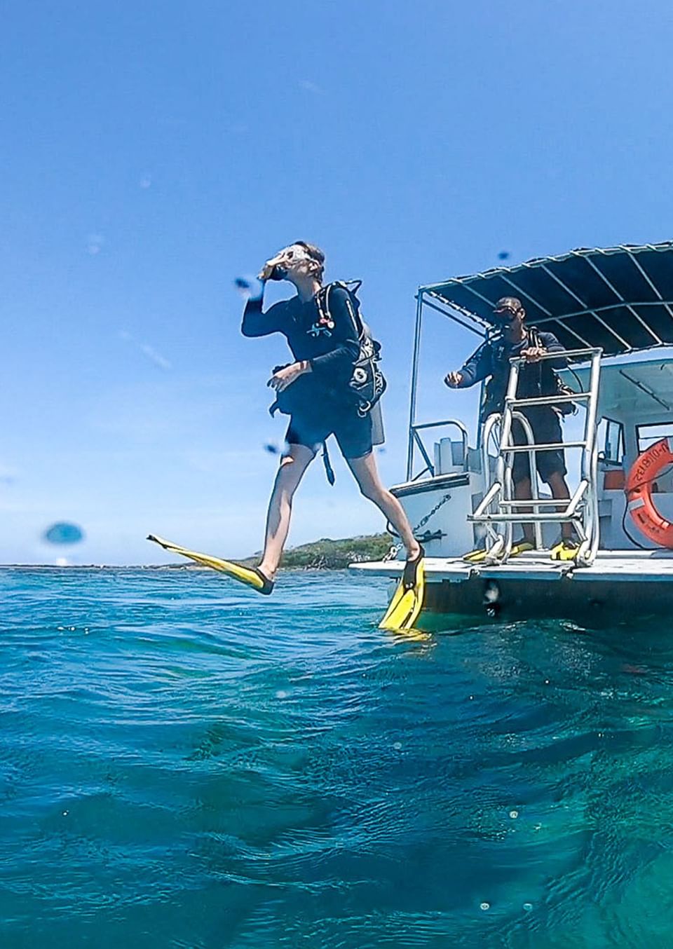 Scuba diver jumping into the ocean from a boat at Barefoot Cay Resort & Marina
