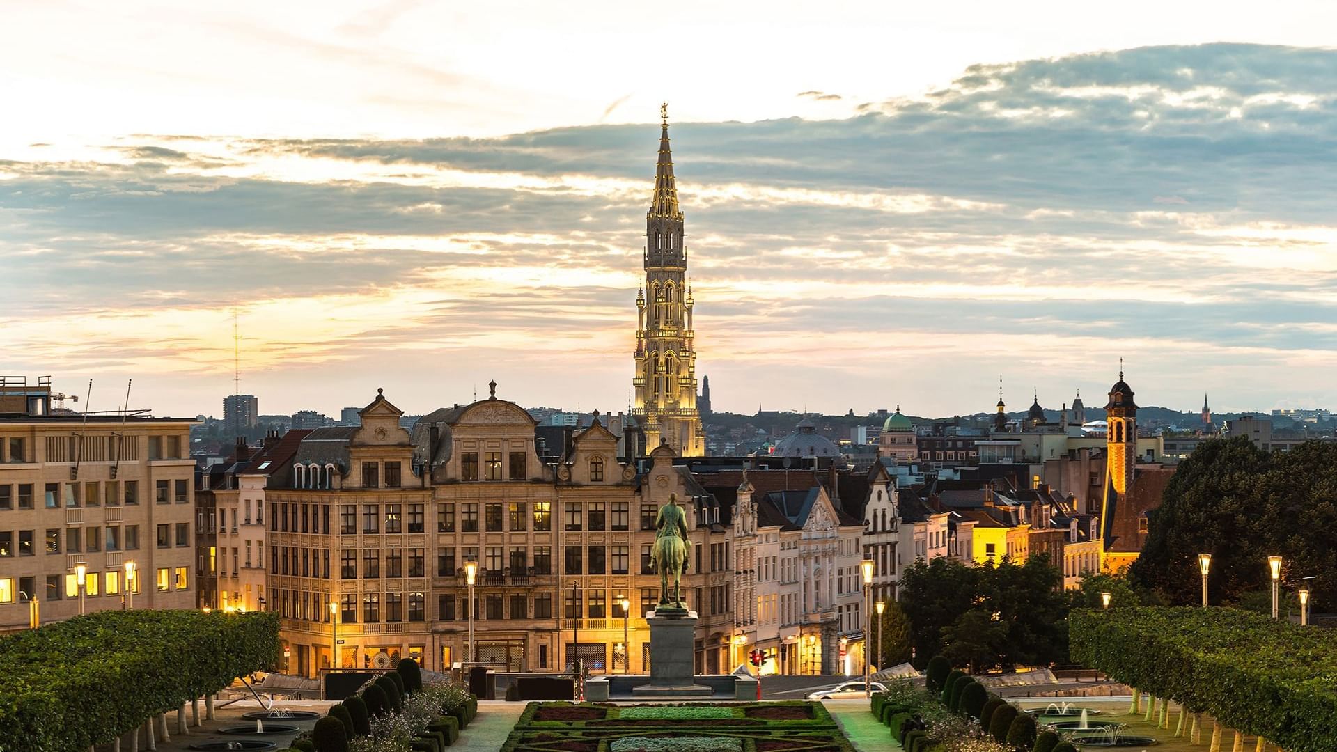 Sunset view of Brussels, showcasing buildings and the iconic spire of the Town Hall near Warwick Hotels and Resorts
