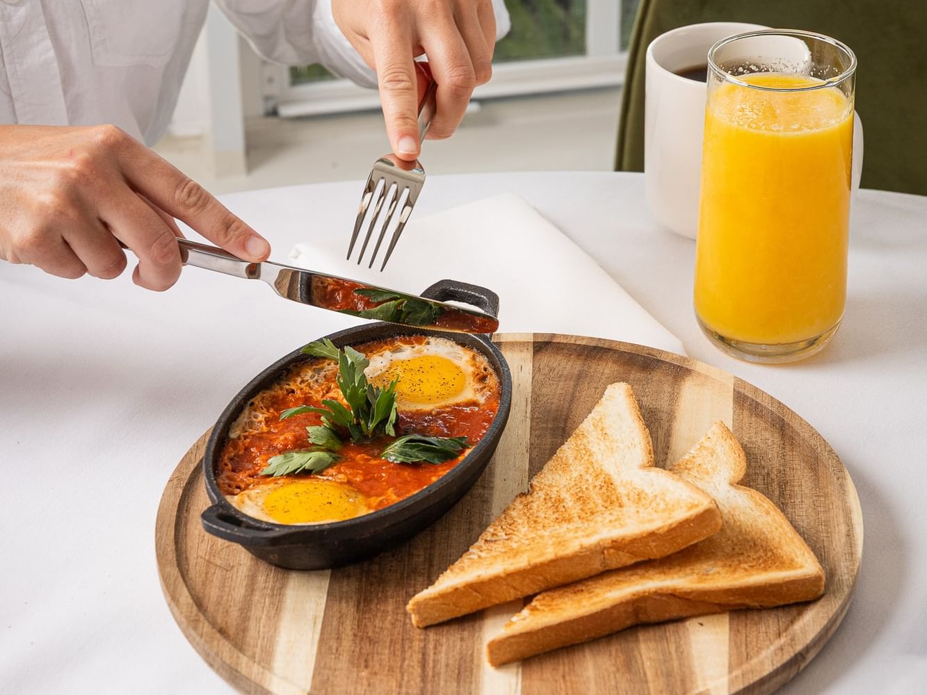 Guest enjoying baked eggs with toast, orange juice, and coffee at Kenmore Bed & Breakfast