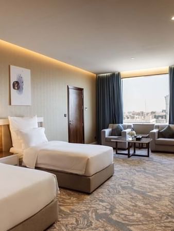 Superior King / Queen Room features Twin beds in a suite by a sitting area at Cantonal Hotel by Warwick Riyadh