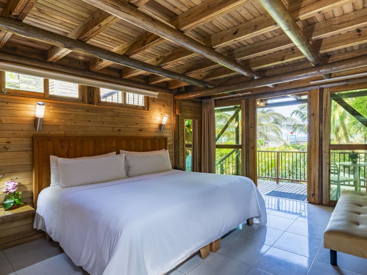 Comfy bed and couch with balcony area in Bungalow room at Hotel Isla Del Encanto