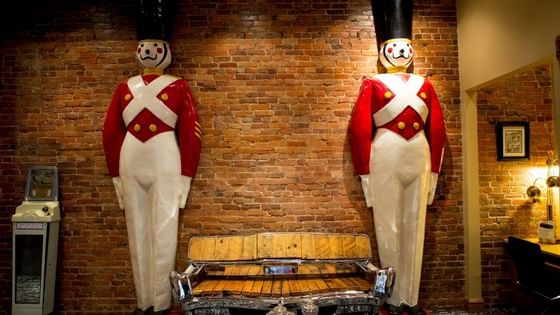 Two statues of nutcrackers, brick wall & bench at Retro Suites Hotel