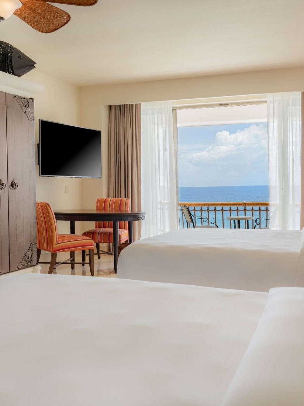 Two Double beds with a TV and a balcony area in Junior Suite Ocean view at Marquis Los Cabos Resort