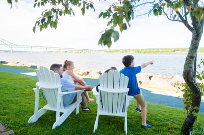 Family sitting in armchairs at Ritchie Wharf Park near Rodd Miramichi River, perfect for Miramichi, Canada hotel