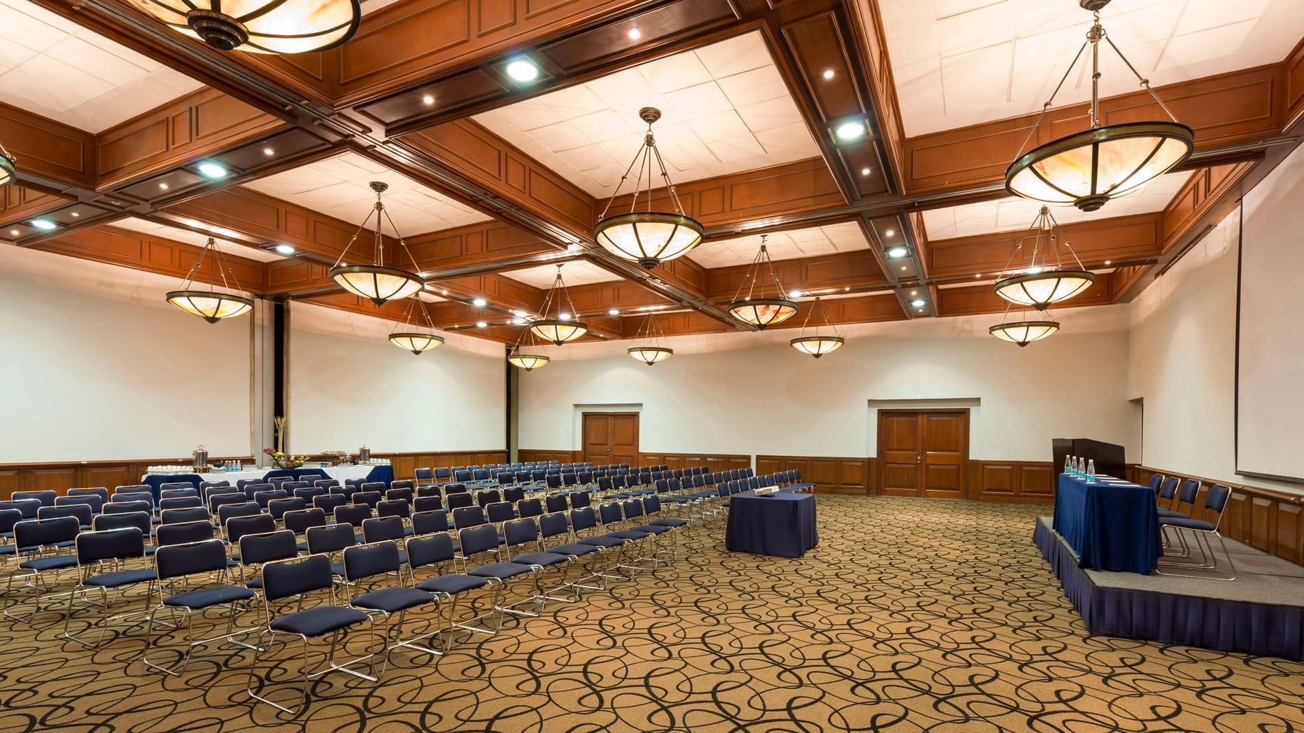 Camino Real meeting room with theater-style seating and hanging lamps at Camino Real Puebla Angelópolis