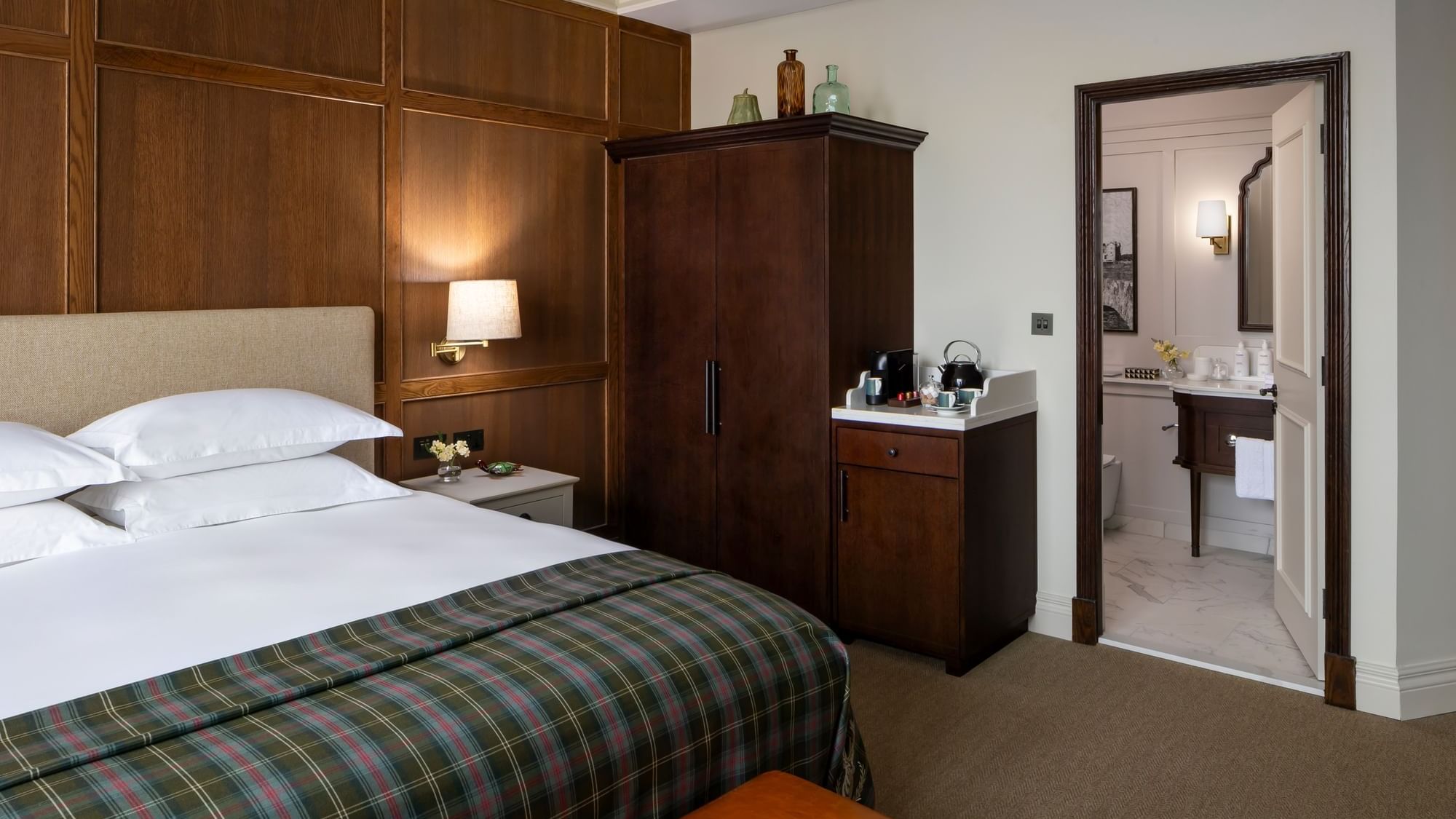 Deluxe room with bed, side table, and wardrobe next to the bathroom at Seaton House hotel