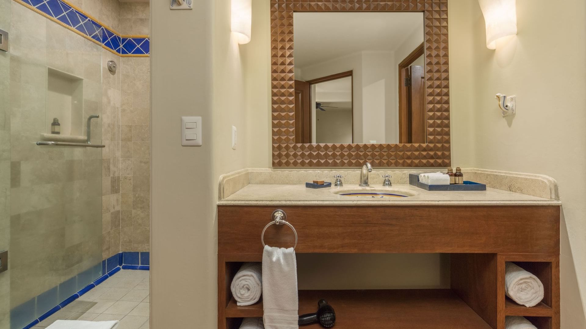 Bathroom with wood-framed mirror vanity and glass shower in the Studio 2 Queen Beds at Hacienda Del Mar Los Cabos.