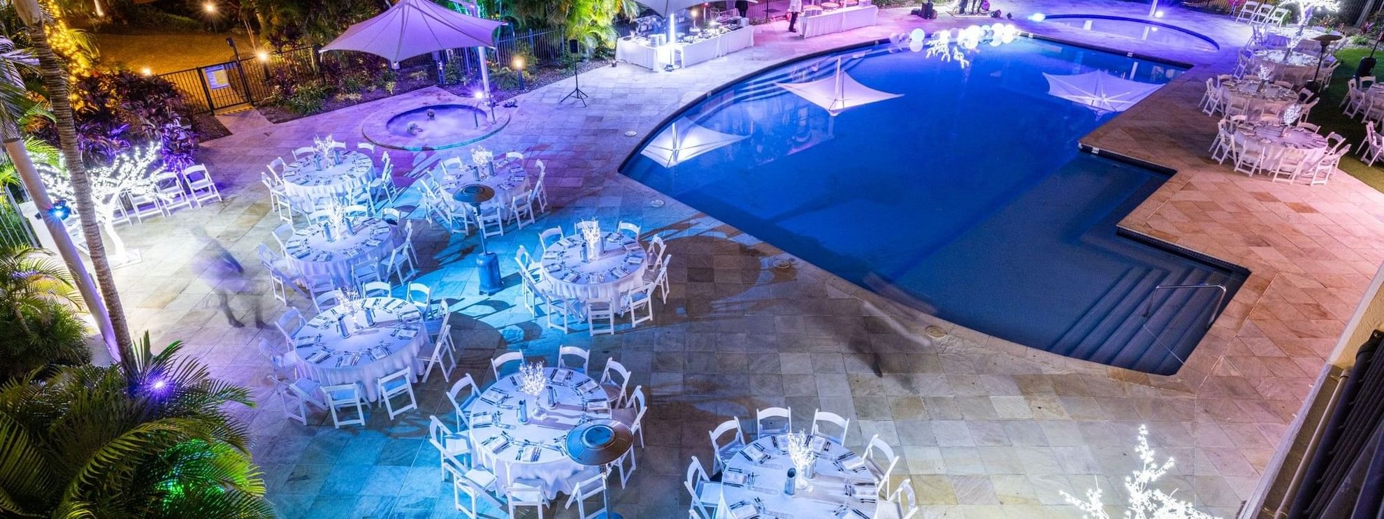 Decorated poolside event space with tables and chairs at Mercure Gold Coast Resort in Carrara.