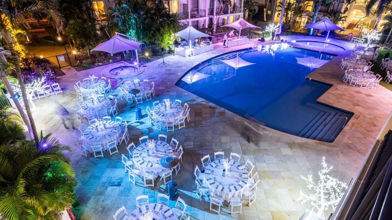 Decorated poolside event space with tables and chairs at Mercure Gold Coast Resort in Carrara.