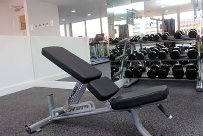 A weight benches with dumbells in a Fitness Center at Courtleigh Hotel and Suites