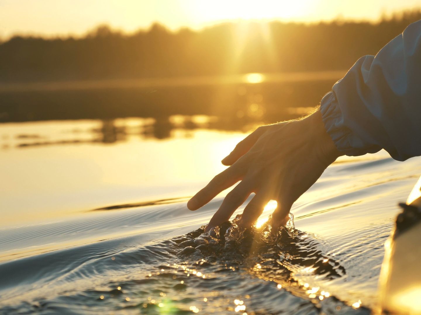 Man touching water while riding kayak, Lodge at Schroon Lake