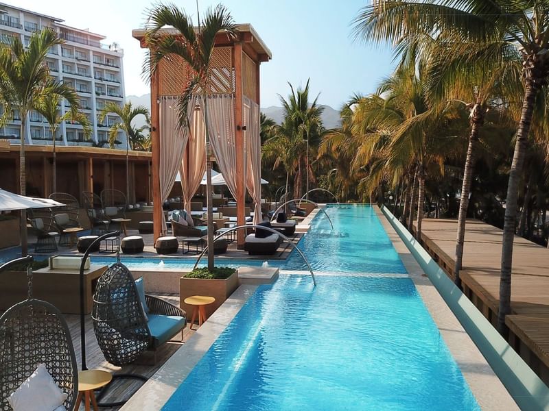 Outdoor pool area with sunbeds and cabana at Fiesta Americana