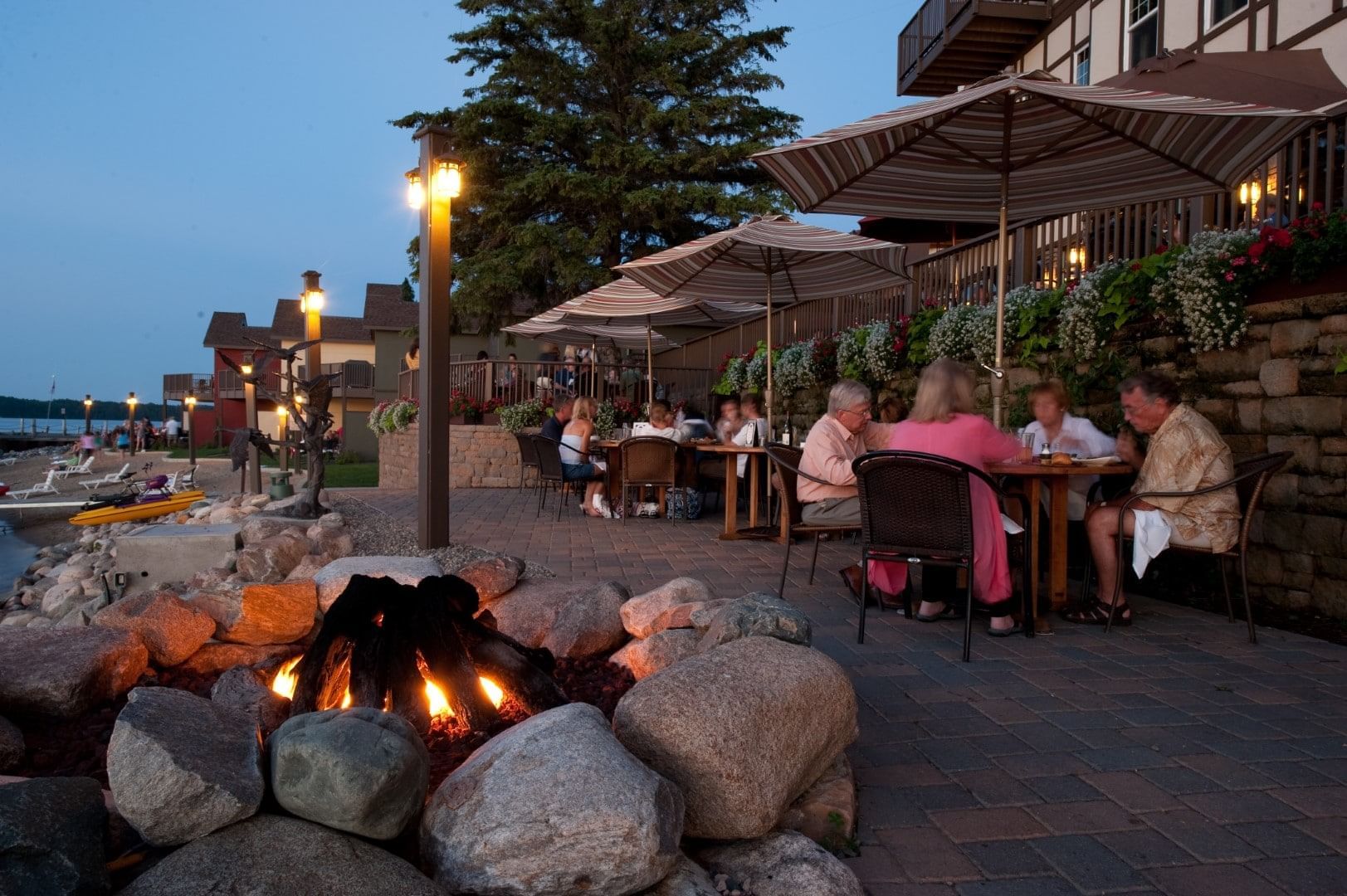Fire Pit rock with dining setup by lake at Chase on The Lake