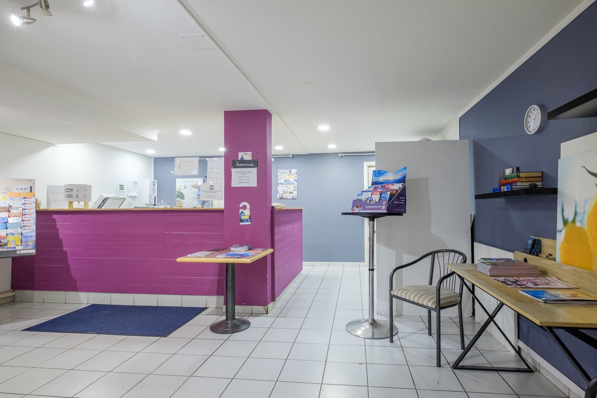 Bright lobby with a marble reception desk & colorful ceiling lights at Residhotel Villa Maupassant Cannes