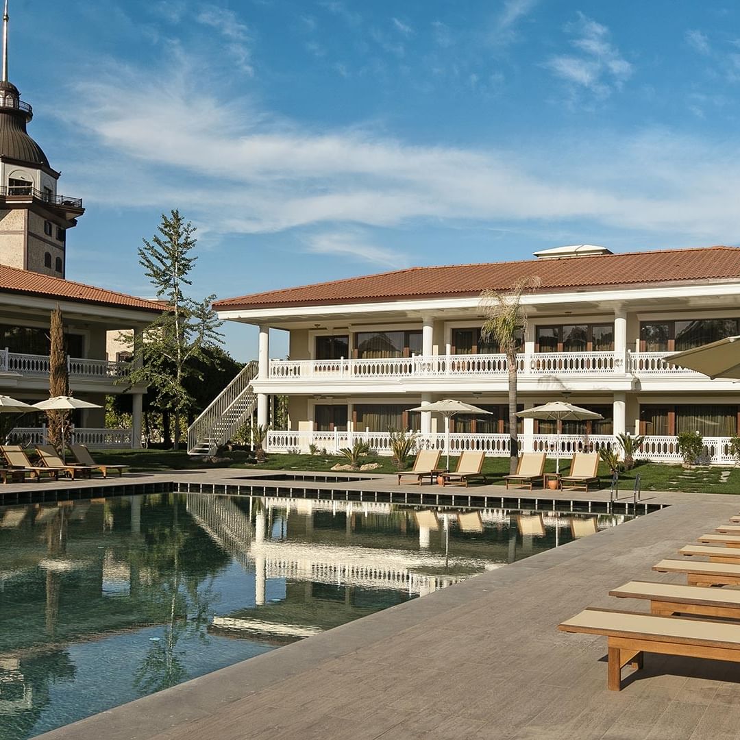 Lake House im Titanic Mardan Palace – Pool, Liegestühle und Sonnenschirme.