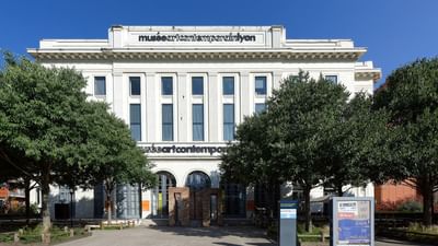 Museum of Contemporary Art of Lyon, surrounded by trees and a clear blue sky near Warwick Reine Astrid Lyon