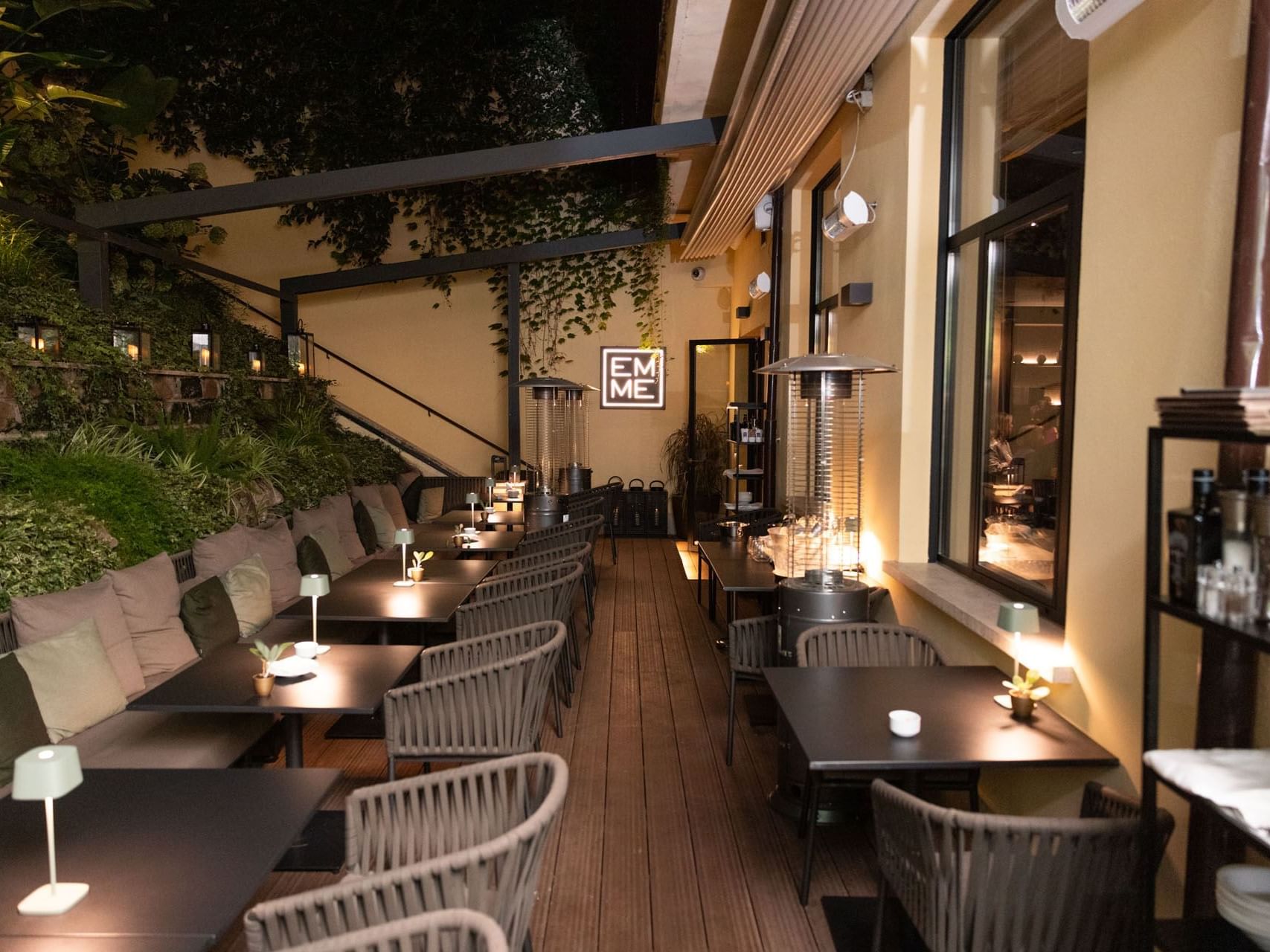 The outdoor dining area at night in EMME Restaurant